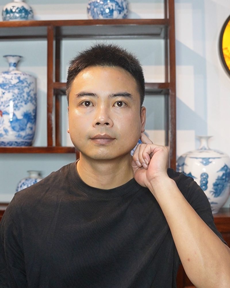 Nguyen Duy Phong looking at the camera with one finger pressing in front of his ear